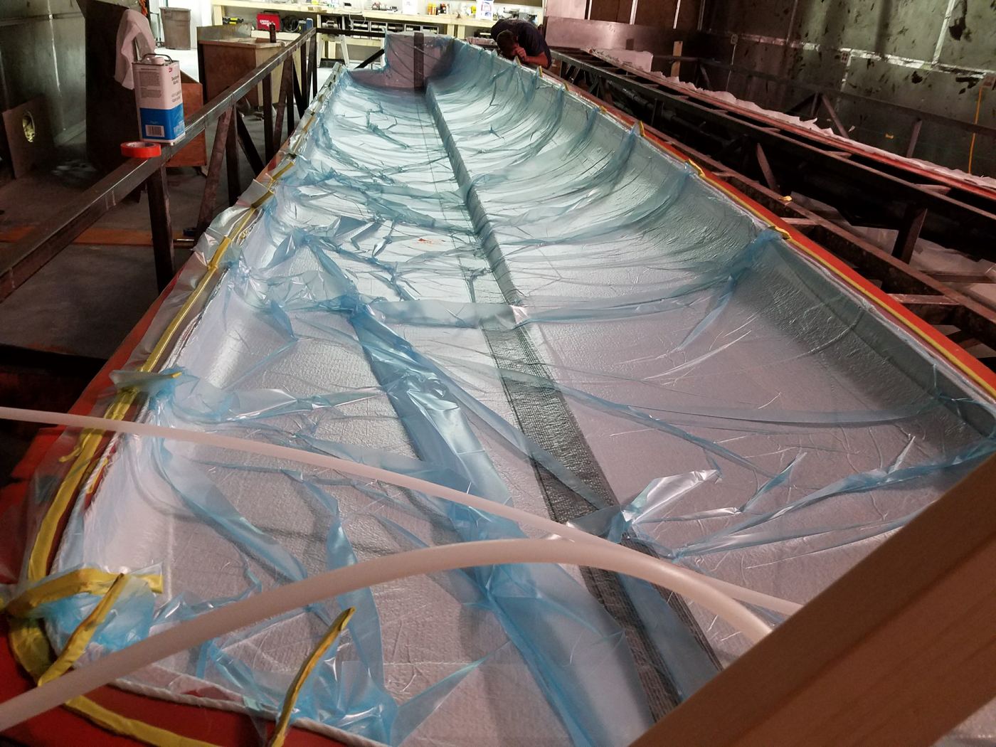Hull laminate under the vacuum bag for debulking.